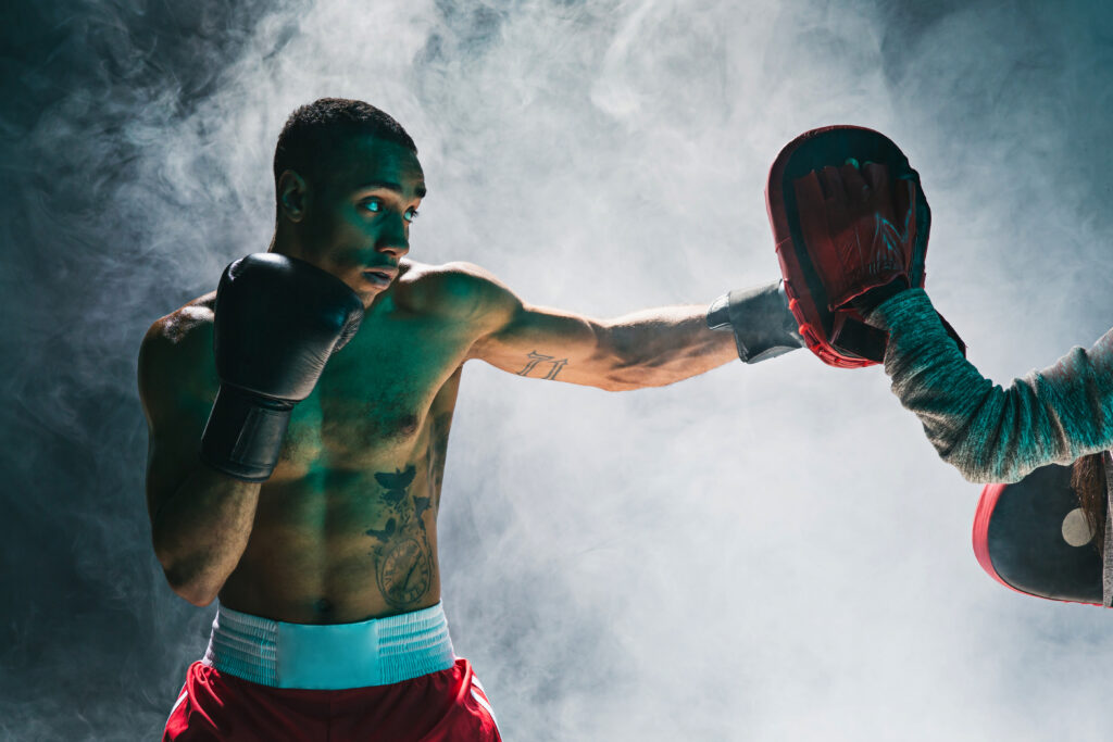 Afro american male boxer. Young man boxing workout in a fitness club. Muscular strong man on background black studio