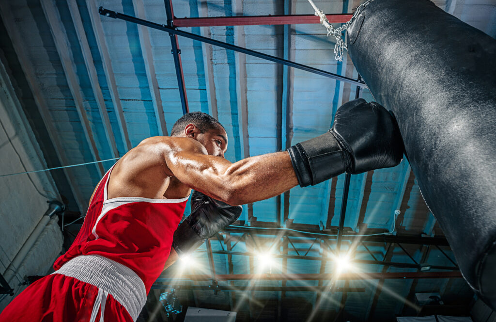 muscular-man-punching-heavy-bag-in-gym-2026-04-13-00-35-31-utc